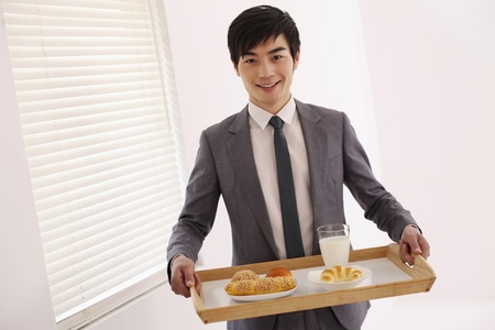 Man carrying breakfast in trayの写真素材