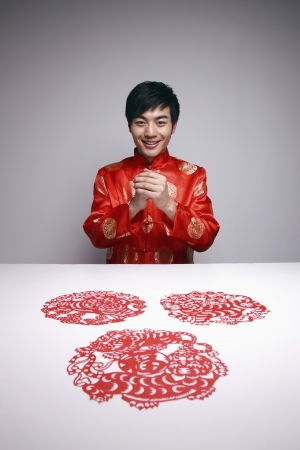 Man with hands clasped wishing Happy Chinese New Yearの写真素材