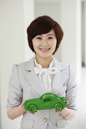 Businesswoman holding at wooden car modelの写真素材