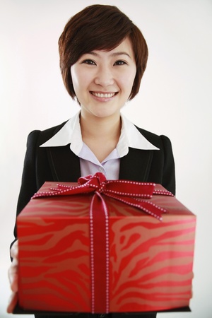 Businesswoman holding a red gift boxの写真素材