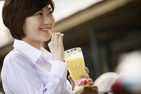 Businesswoman drinking a glass of orange juiceの写真素材