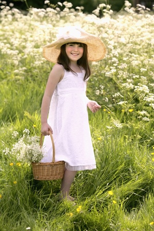 Girl in meadow picking flowersの写真素材