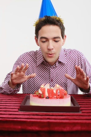 Man blowing candles on birthday cakeの写真素材