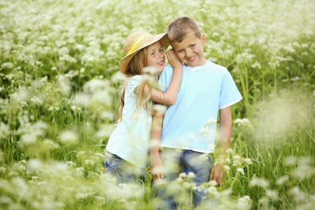 Girl whispering into boy's earの写真素材