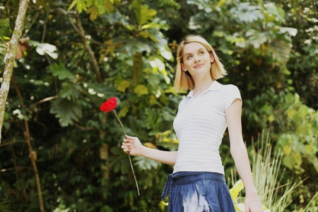 Woman holding red flowerの写真素材