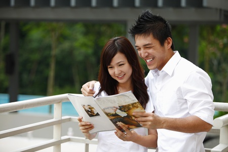 Man and woman reading magazineの写真素材
