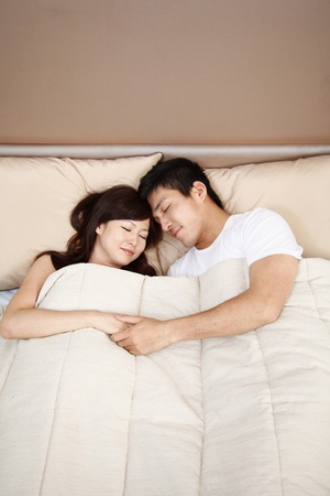 Man and woman sleeping in bedの写真素材