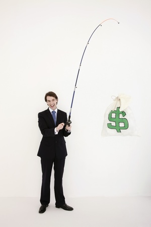 Businessman fishing out a money bagの写真素材