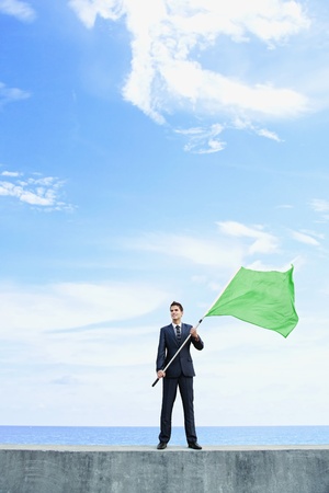 Businessman holding a green flagの写真素材