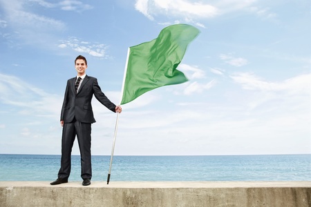 Businessman holding a green flagの写真素材