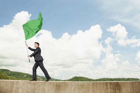Businessman waving a green flagの写真素材