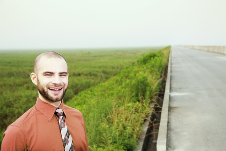 Businessman in green with field in the backgroundの写真素材