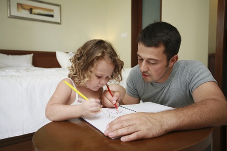 Man helping his daughter to colourの写真素材