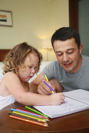 Man helping his daughter to colourの写真素材