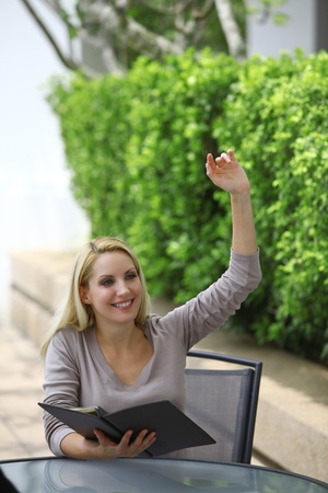 Woman with menu raising her handの写真素材 [40008980886] - イメージマート