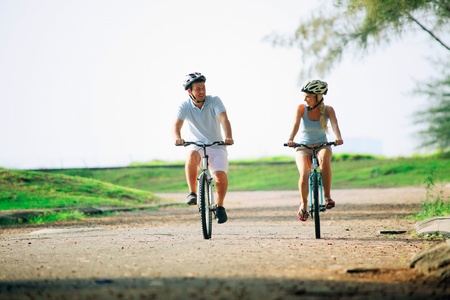 Man and woman cycling in the parkの写真素材