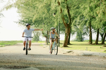 Man and woman cycling in the parkの写真素材