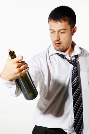 Drunk businessman looking at an empty bottleの写真素材