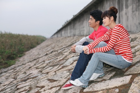 Man and woman sitting together outdoorsの写真素材
