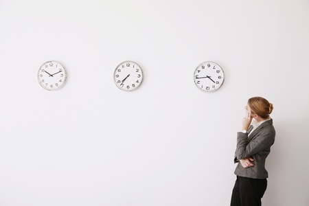Businesswoman looking at the time on the clocksの写真素材