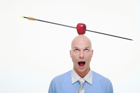 Man with apple pierced by arrow balanced on his headの写真素材