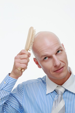 Bald man combing his headの写真素材