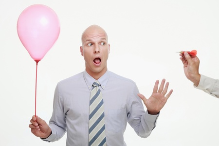 Hand aiming dart at balloon, businessman in shockの写真素材