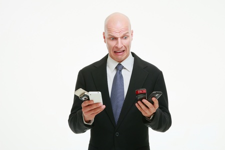 Businessman looking at all his mobile phonesの写真素材