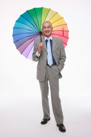 Businessman holding a colourful umbrellaの写真素材
