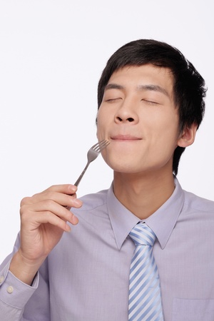 Businessman eating with fork Businessman eating with fork