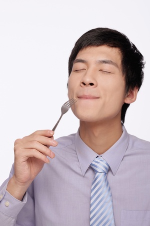 Businessman eating with forkの写真素材