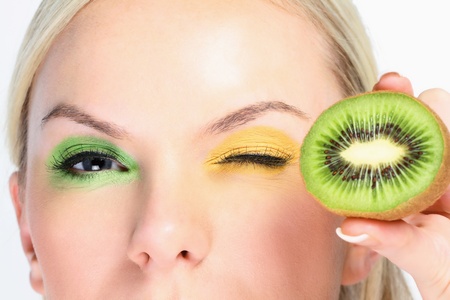 Woman with halved kiwi fruitの写真素材