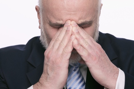 Businessman with hands on head and eyes closed