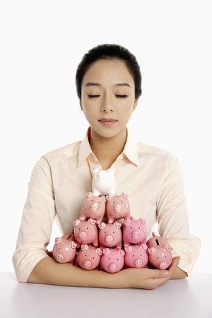 Businesswoman with an armful of piggy banksの写真素材