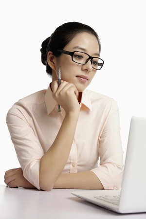 Businesswoman thinking while using laptopの写真素材