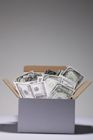 Cardboard box filled with moneyの写真素材