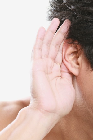 Man with hand cupped on ear listeningの写真素材