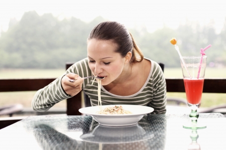 Woman enjoying a plate of pastaの写真素材