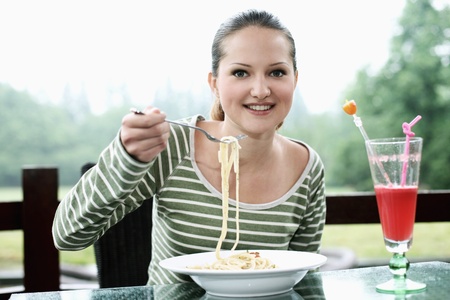 Woman enjoying a plate of pastaの写真素材