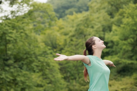 Woman with arms outstretched and eyes closedの写真素材