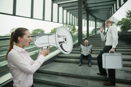 Businesswoman speaking through megaphoneの写真素材