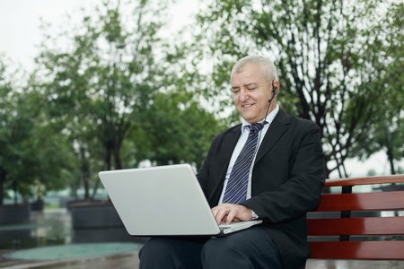 Businessman with telephone headset using laptopの写真素材