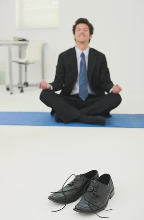 Businessman meditating in officeの写真素材