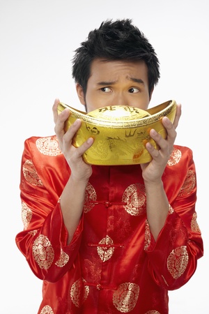 Man posing for the camera while holding a gold ingot の写真素材
