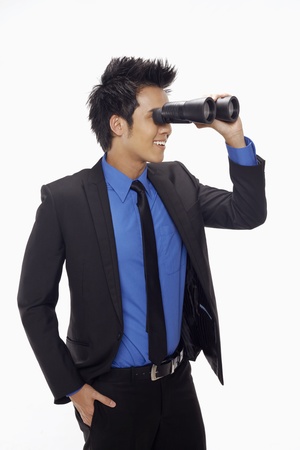 Businessman looking through binocularsの写真素材