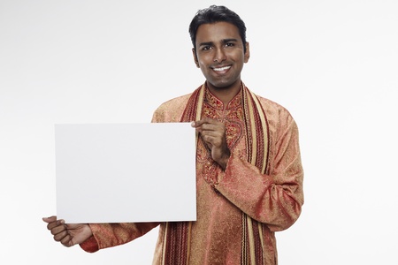 Man in traditional clothing holding up blank placardの写真素材