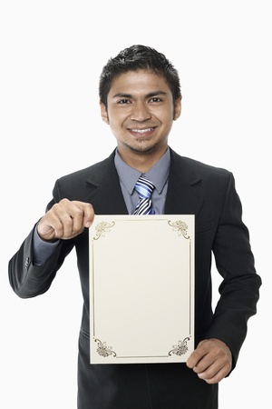Businessman holding a blank certificateの写真素材