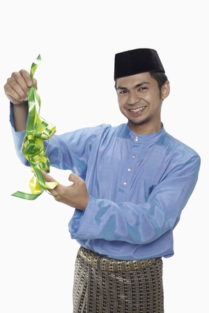 Man in traditional clothing holding ketupatの写真素材
