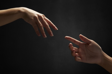 Hands reaching out to one anotherの写真素材