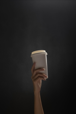 Human hand holding a disposable cupの写真素材